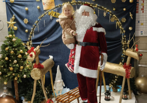 św. Mikołaj z małą klientką na ściance